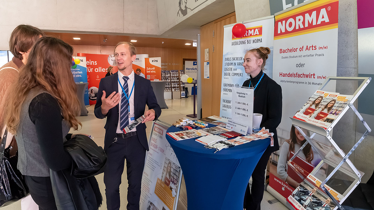 Austellende und Besuchende am Stand der Firma Norma