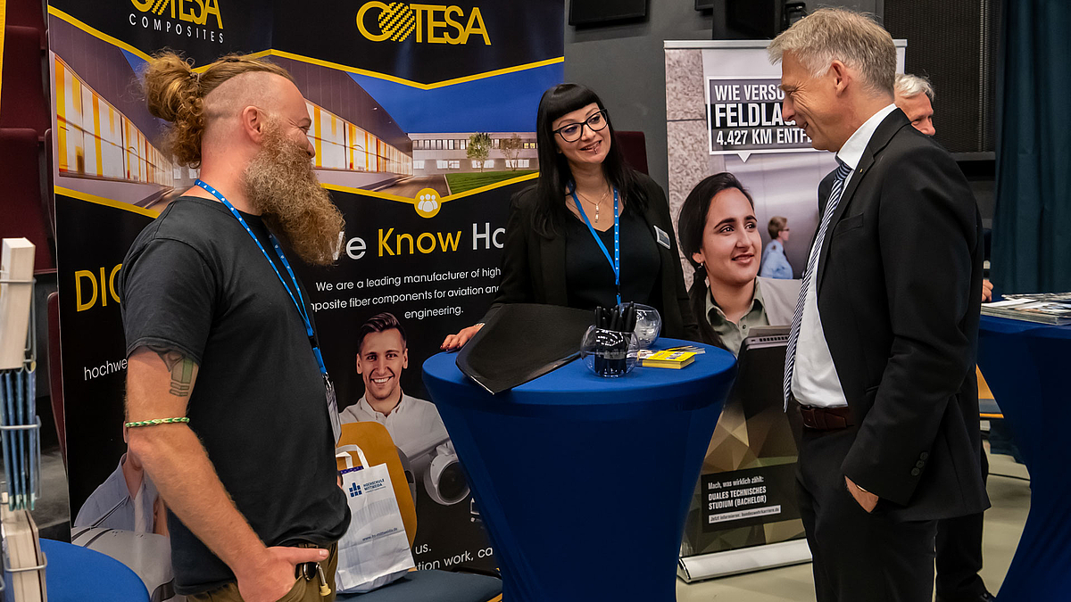 Rektor Volker Toklmitt am Stand der Firma Cotesa im Gespräch mit Firmenvertreter:innen