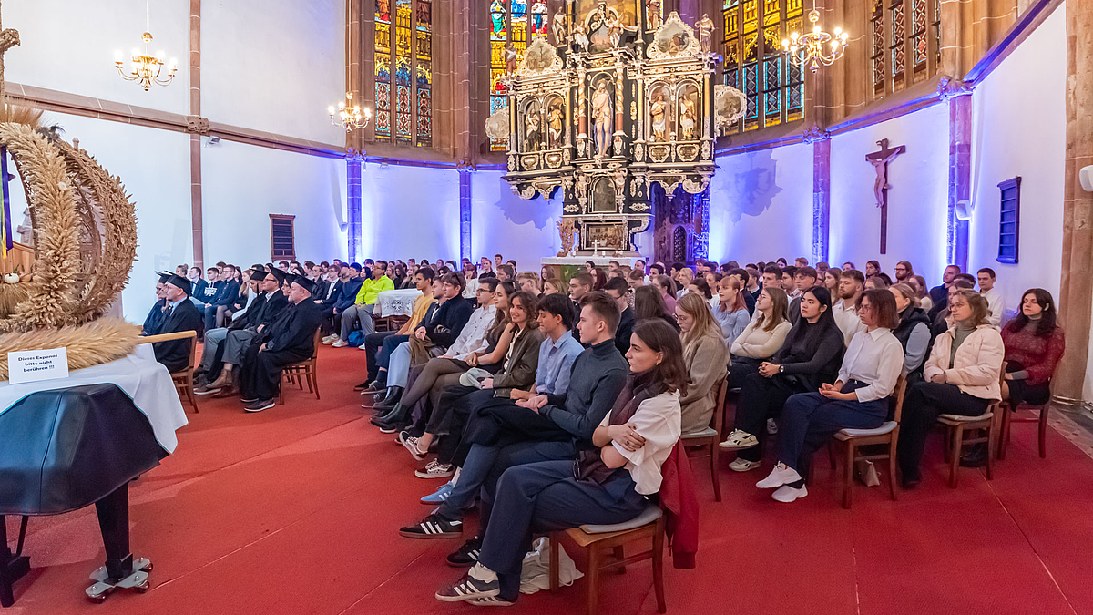 Erstsemester im Altarraum. Am linken Bildrand ist die Erntekrone zu sehen.