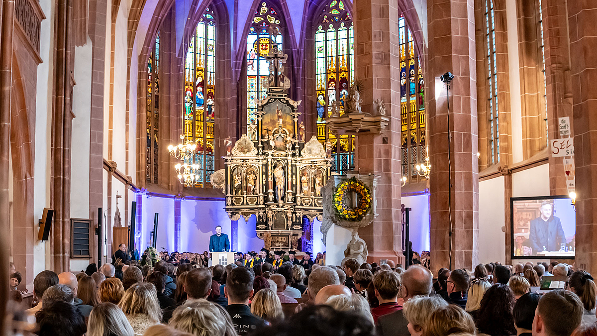 Blick über die Köpfe der Besucher:innen in Richtung Altarraum.