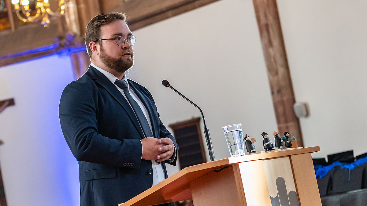 Maximilian Schulze im Anzug am Rednerpult